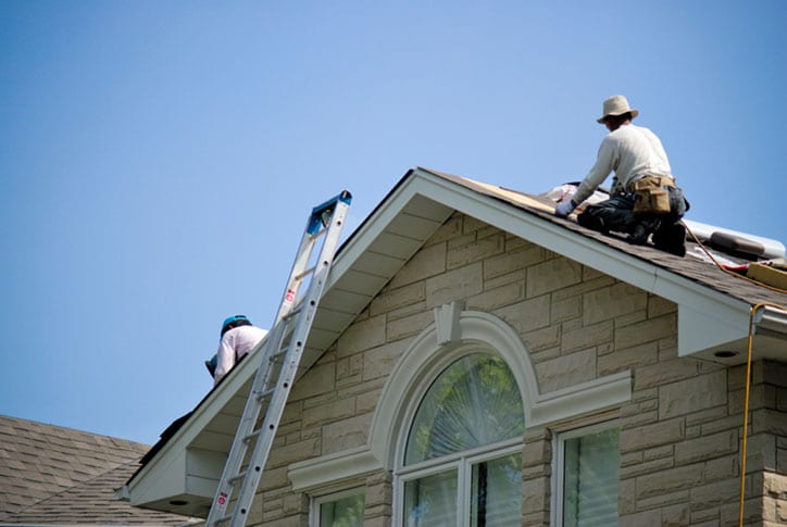 Roofing contractors working on a home.