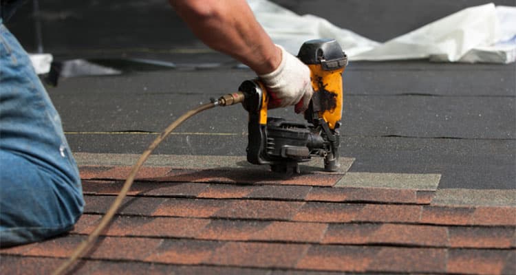 Closeup of roofers in Rochester MI Using Nailer.